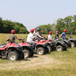 Kids sitting on stationery Quad bikes listening to instructor